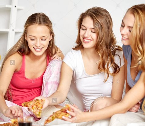 happy-friends-or-teen-girls-eating-pizza-at-home-FXW5J3-1-475x413